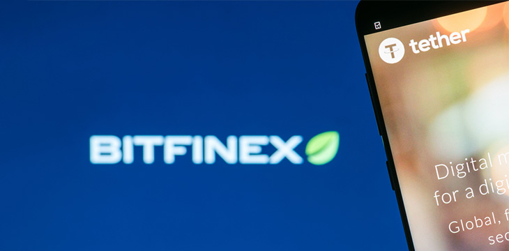 Tether cryptocurrency website displayed on the smartphone screen with blurred Bitfinex logo on background
