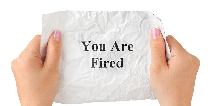 someone holding a crumpled you are fired paper