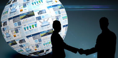 business people shaking hands in front of a globe