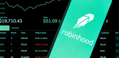 stocks on screen with a robinhood logo on a phone
