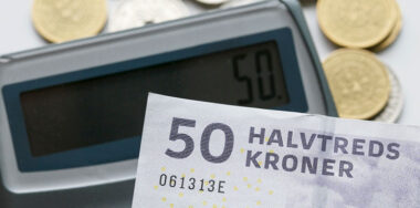 A fifty kroner note with a selection of mixed Danish coins with a calculator