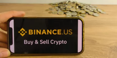 Binance.US cryptocurrency exchange logo on mobile phone