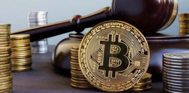 stack of bitcoins and gavel on a desk