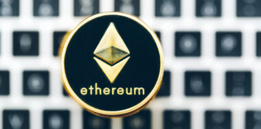 Circular gold lining Ethereum logo with laptop as background
