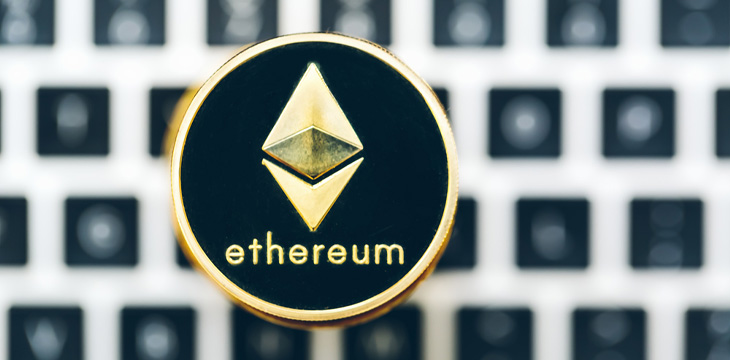 Circular gold lining Ethereum logo with laptop as background