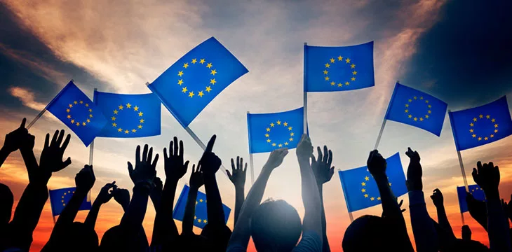 Silhouettes of people waving European Union Flags