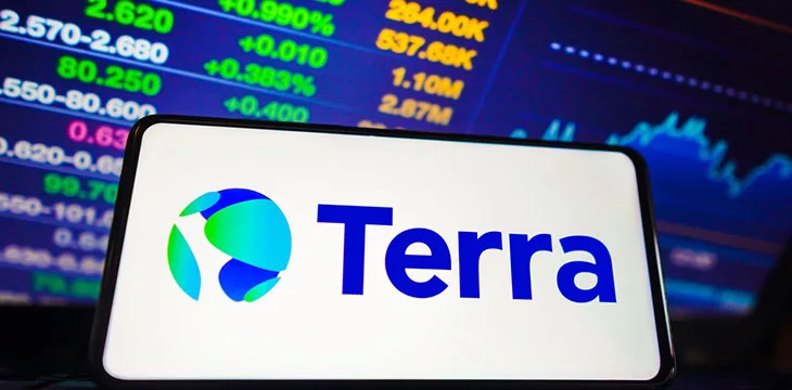 Terra logo on smartphone in front of stocks