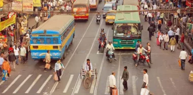 Crossroad of busy modern city in Asia with cars, bikes, walking people and buses
