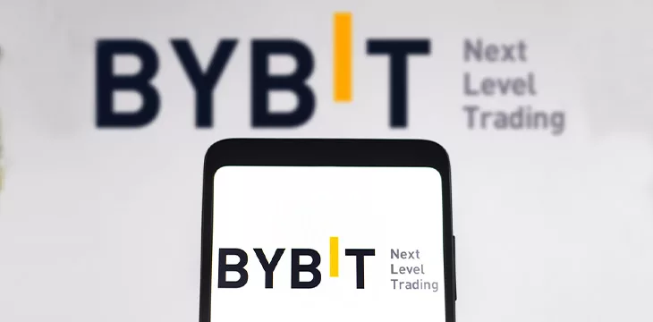 the Bybit logo is displayed on a smartphone screen and in the background