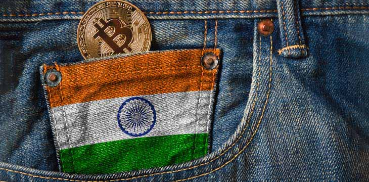 Golden BITCOIN (BTC) cryptocurrency in the pocket of jeans with the flag of Republic of India on Jeans Denim Texture