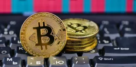 Golden bitcoin on notebook keyboard Golden bitcoin on notebook keyboard with chart