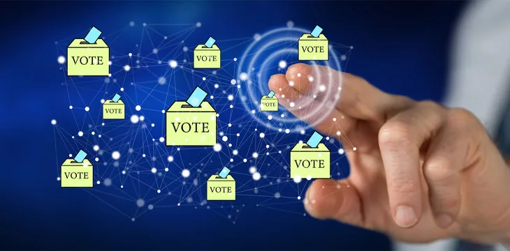 Man touching an online voting concept on a touch screen with his finger