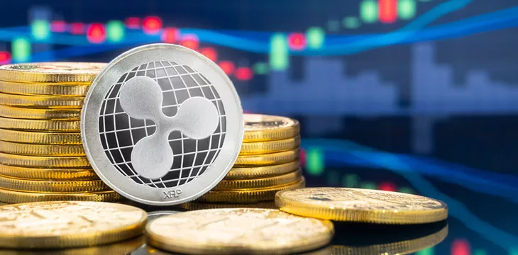 Ripple (XRP) Coin Cryptocurrency with stocks chart in the background