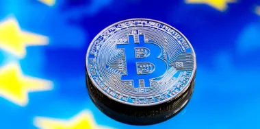 Coins Bitcoin, against the backdrop of Europe and the European flag, the concept of virtual money, close-up. Conceptual image of digital crypto currency.