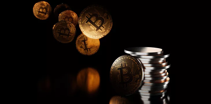 3D rendering of floating gold Bitcoins and stack of silver coins