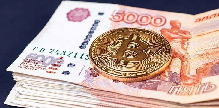 gold bitcoin on top of russian rubles money