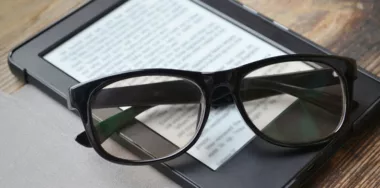 black glasses on top of black ebook reader