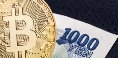 Close-up of a golden bitcoin on 1000 Yen