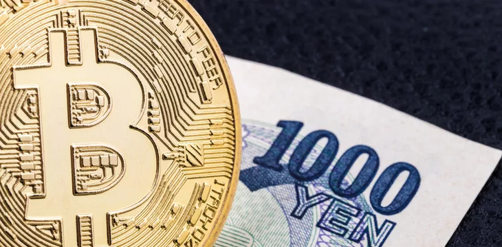 Close-up of a golden bitcoin on 1000 Yen
