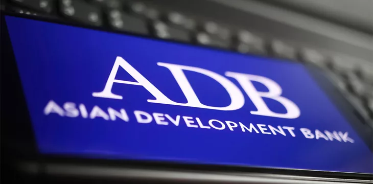 mobile phone with logo lettering of adb asisan development bank on computer keyboard