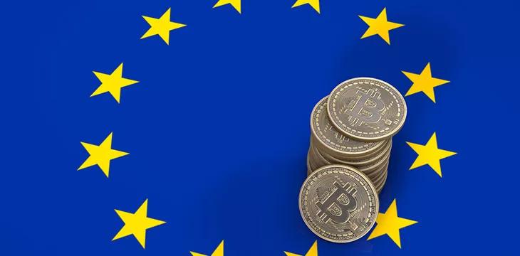 Pile of bitcoins on top of European Union flag