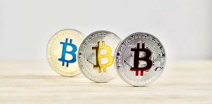 Digital currency physical silver and gold bitcoin coins on the wooden board