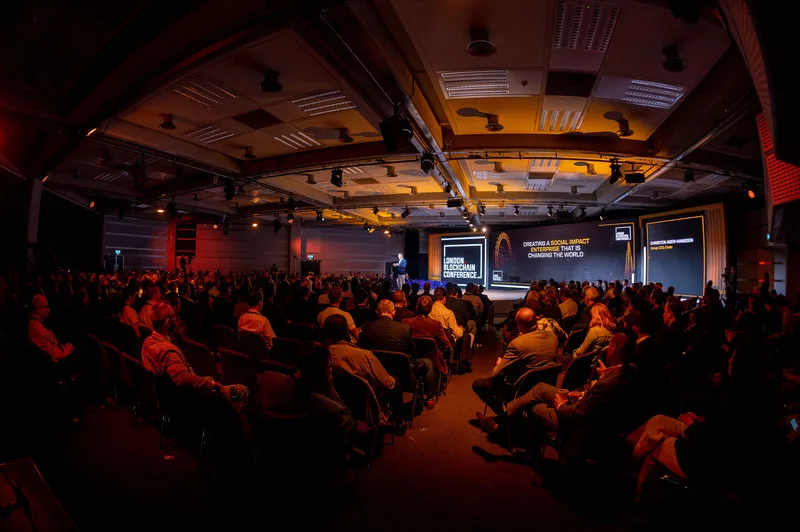 Wide angle shot of the audience and stage at the London Blockchain Conference 2023