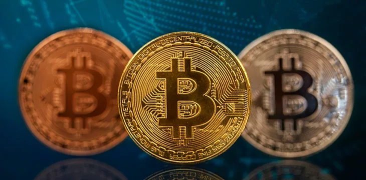 three different colors of bitcoin in blue background