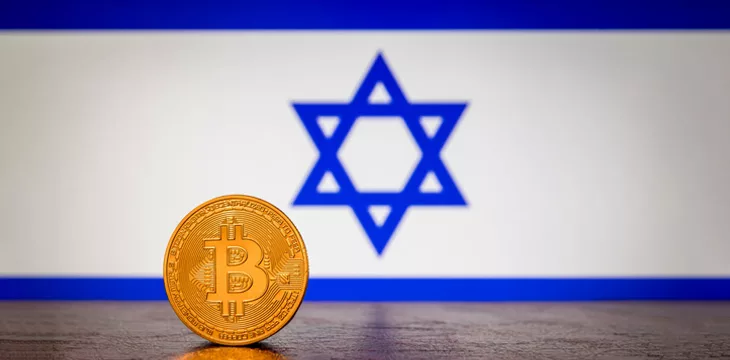 Golden physical Bitcoin with Israel flag in the background