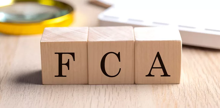 FCA on a wooden cubes with magnifier and calculator, financial concept background