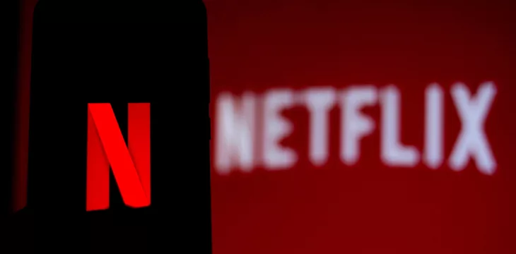 Netflix logo displayed on smartphone screen and in the background