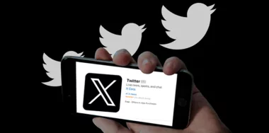 Twitter X app in mobile screen and twitter bird logo in black background