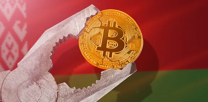 gold bitcoin coin being squeezed in vice on Belarus flag background