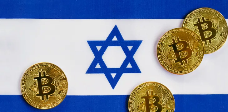 Bitcoin cryptocurrency physical golden bitcoins on an Israeli flag