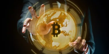 Close up shot of Businessman in black suit with bitcoin symbol hologram effect isolated on background