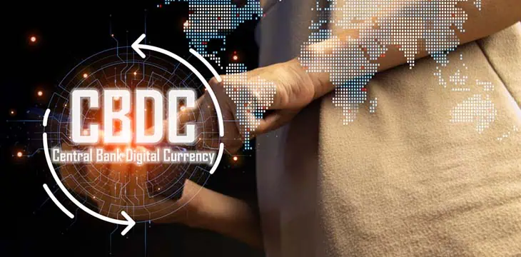 CBDC illustration with a human finger and world map