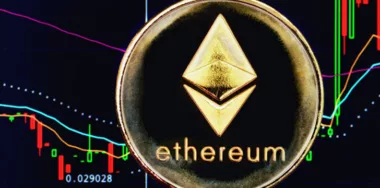 Ethereum cryptocurrency physical coin with graph in the background