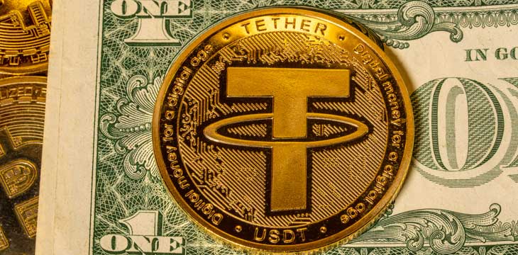 Concept of Tether coin against golden bitcoin coins and a single US dollar note or bill.