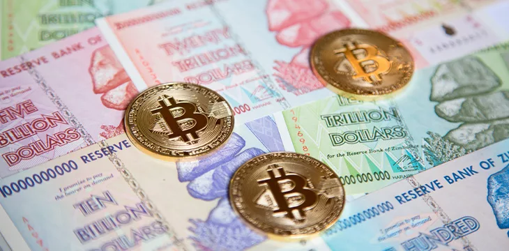 Bitcoins over the background made of Zimbabwe currency