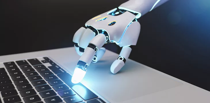 Futuristic robot hand typing and working with laptop keyboard
