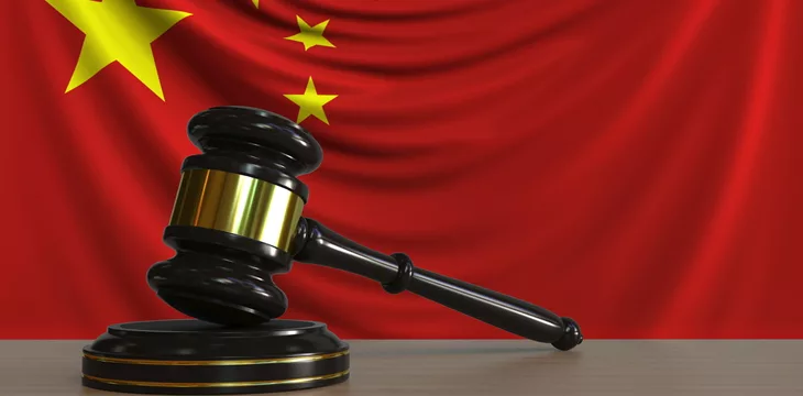 Judges gavel and block against the flag of China