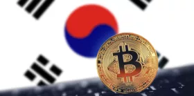 Gold Bitcoin on black keyboard with South Korean flag background