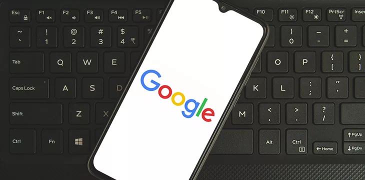 google logo on smartphone screen on top of a keyboard