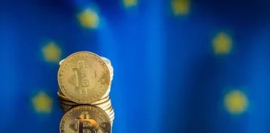 Gold bitcoins and EU flag in the background