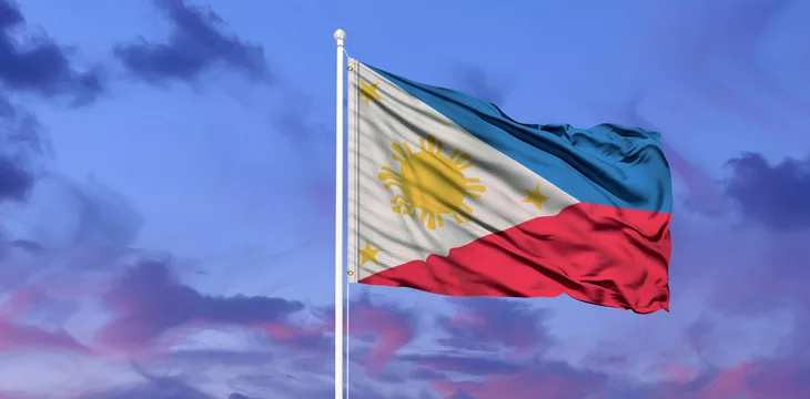 Philippine flag on a pole against blue sky