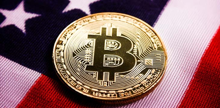 gold bitcoin on top of American flag