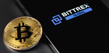 Bittrex Global logo on smartphone with bitcoin