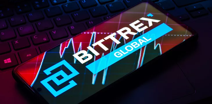 Bittrex logo displayed on smartphone screen on top of computer keyboard