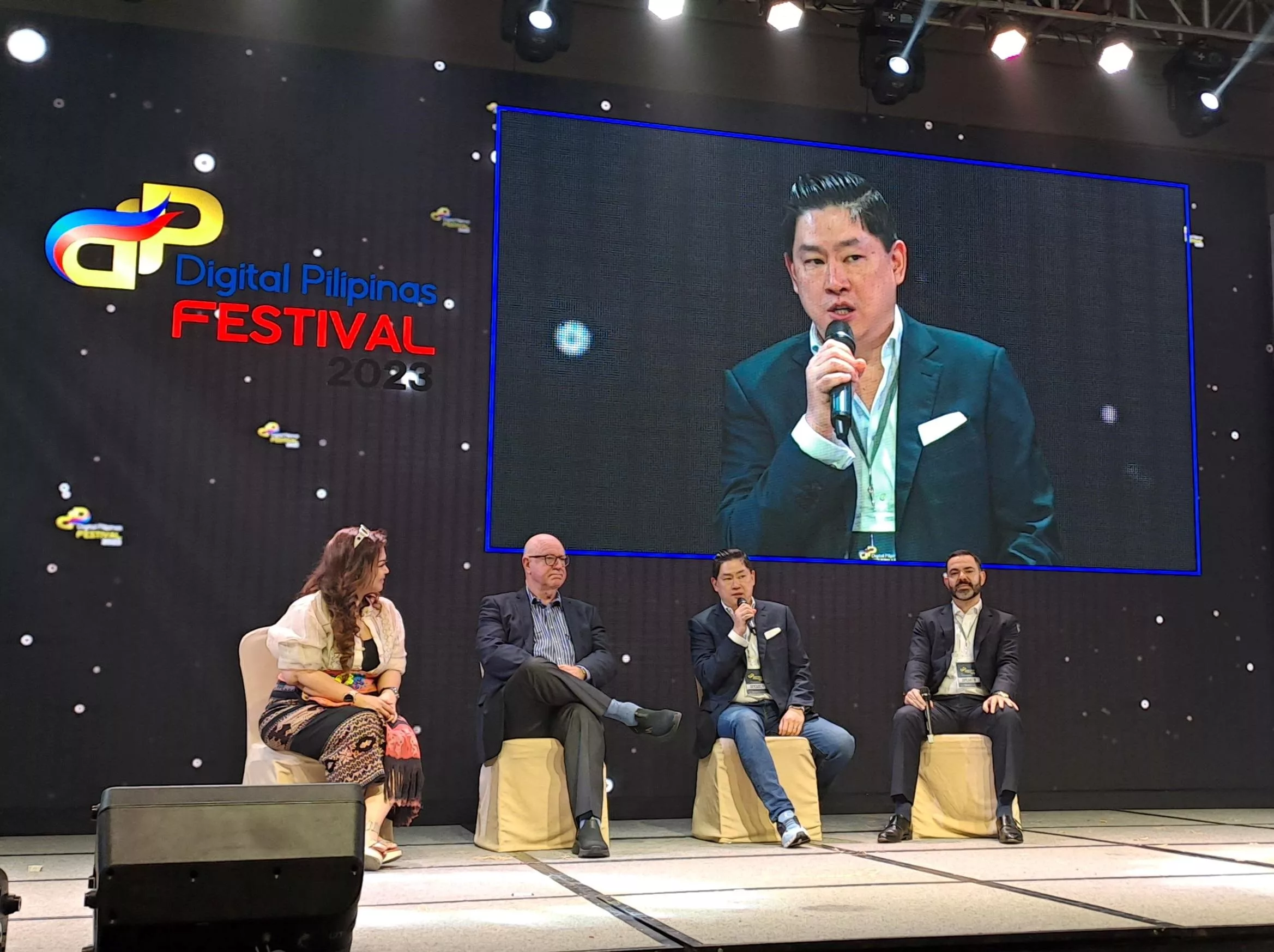 Steve Tsao speaking on stage with the panel
