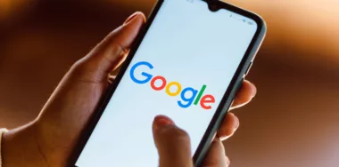 Google logo seen displayed on smartphone screen being held by hand